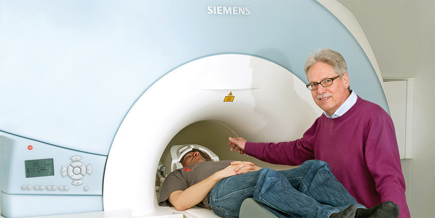 Jens Frahm with a subject being slid into an MRI.