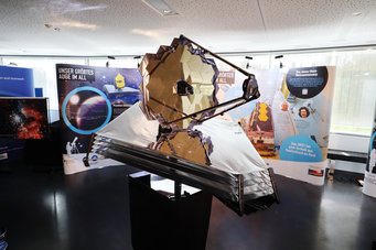 Modell des James Webb Weltraumteleskops im Maßstab 1:10, umgeben von einer Begleitausstellung zur Rolle des Max-Planck-Instituts für Astronomie bei der Entwicklung des Filterrads und zum Teleskop selbst. Ein interaktives Element erlaubt es, die Funktion eines solchen Filterrads selbst auszuprobieren.