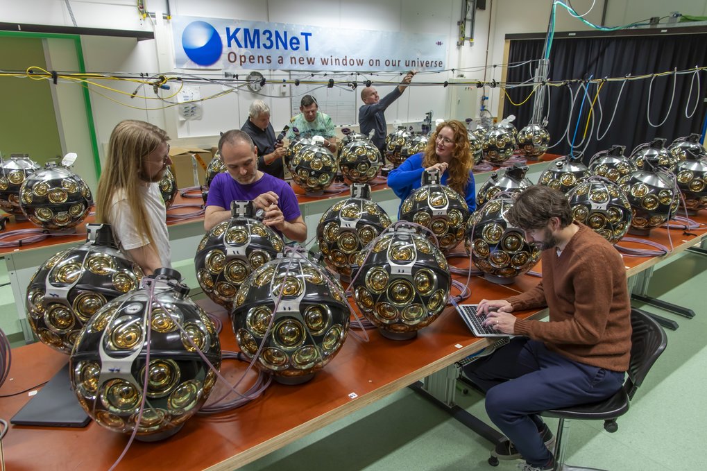 Employees work with spherical devices in a laboratory.